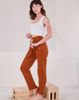 Angled front view of Rolled Cuff Sweat Pants in Burnt Terracotta and vintage off-white Cropped Tank on Alex