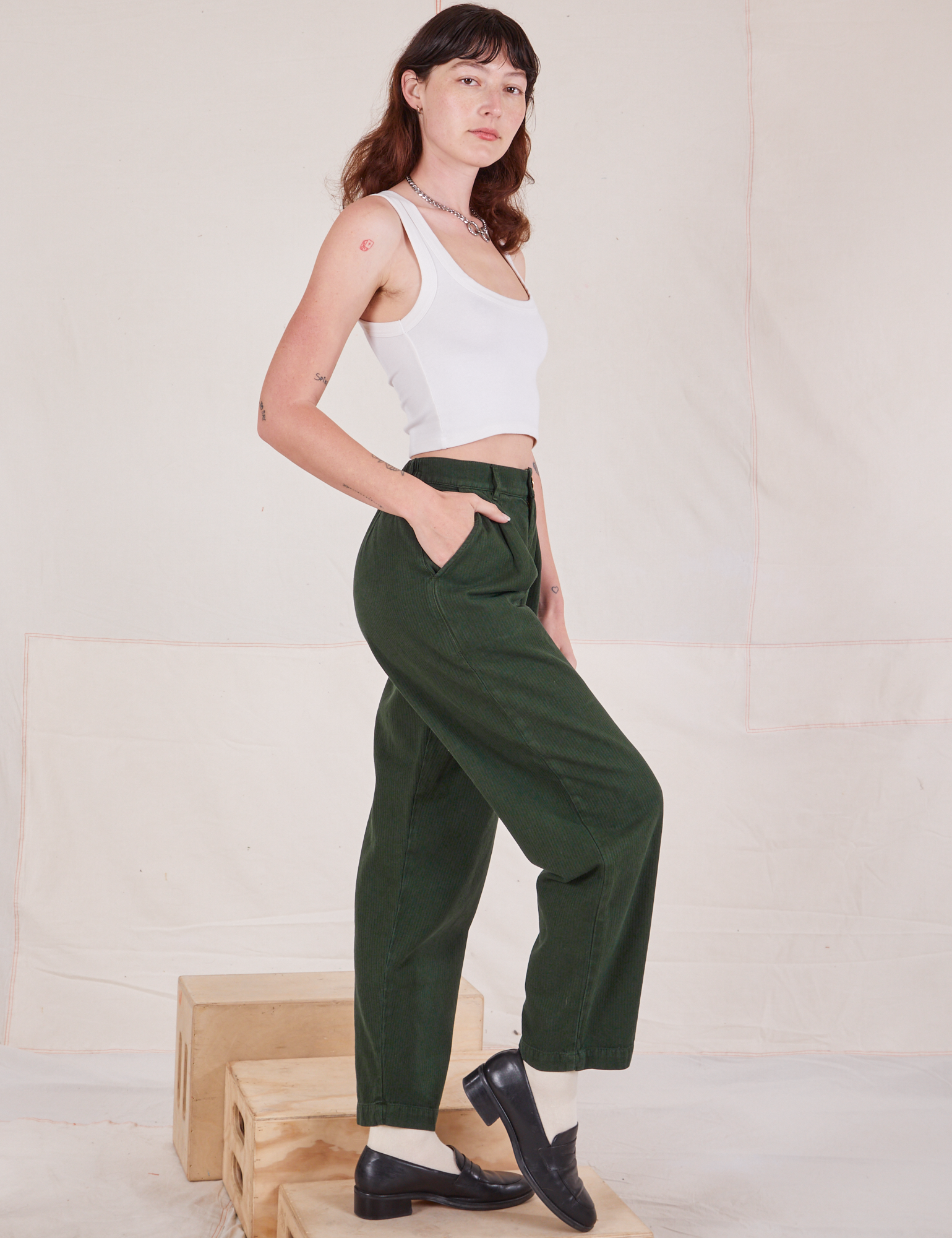 Side view of Heritage Trousers in Swamp Green and Cropped Tank Top in vintage tee off-white on Alex