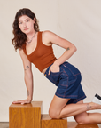 Alex is wearing Carpenter Shorts in Dark Wash and burnt terracotta Cropped Tank