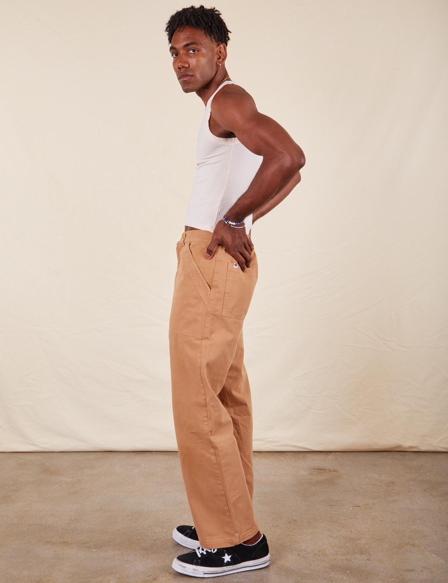 Side view of Long Work Pants in tan and wearing paired with Tank Top in vintage tee off-white worn by Jerrod