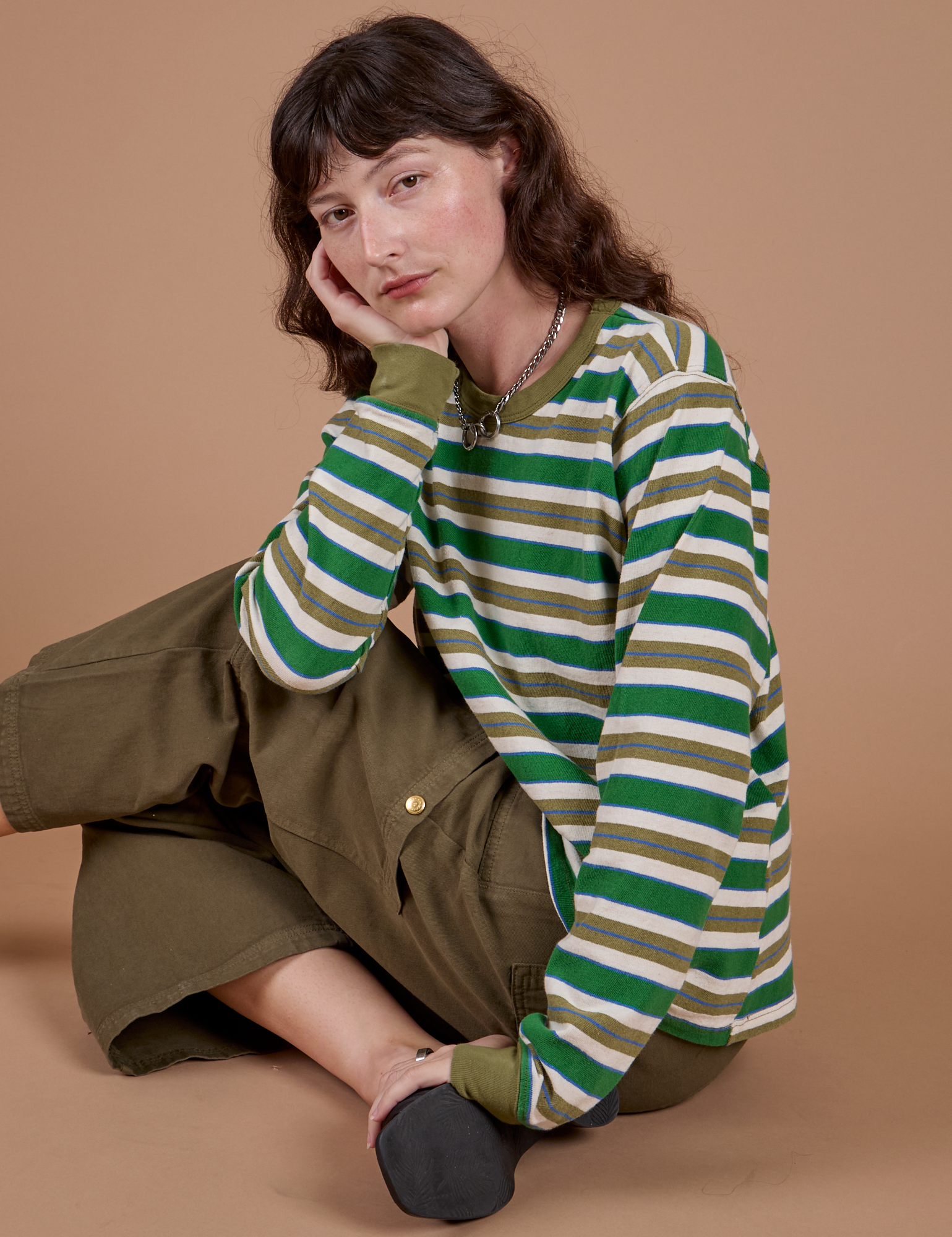 Alex is wearing Long Sleeve Striped Burly Tee in Green paired with surplus green Drop Pocket Cargo Pants