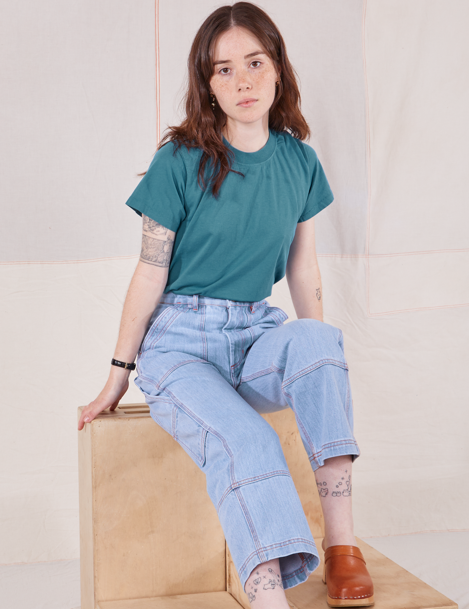 Hana is wearing Organic Vintage Tee in Marine Blue and light wash Carpenter Jeans