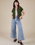 Alex is wearing Pantry Button-Up in Evergreen and light wash Indigo Wide Leg Trousers