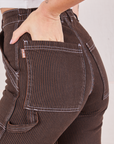 Railroad Carpenter Jeans in Fudgesicle Brown back pocket close up. Alex has her hand in the pocket.