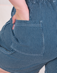 Close up of Ashley's hand in the back pocket of Railroad Carpenter Shorts in Baby Blue