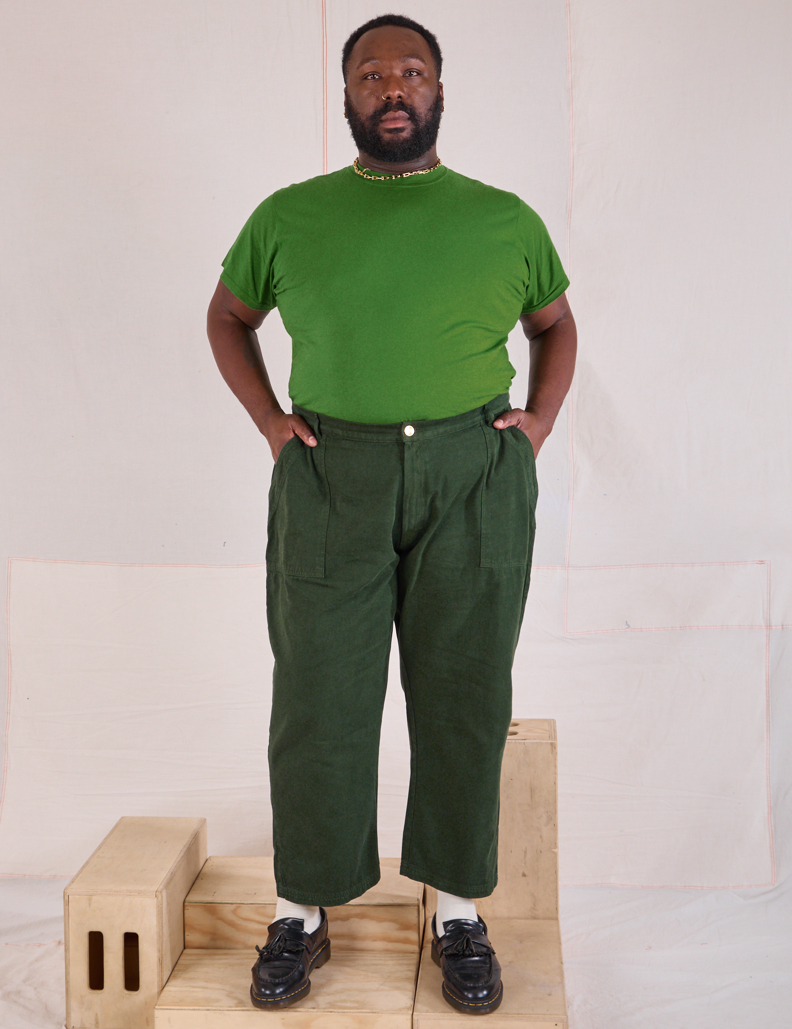 Elijah is 6'3" and wearing 1XL Mid-Rise Work Pants in Swamp Green paired with a lawn green Organic Vintage Tee