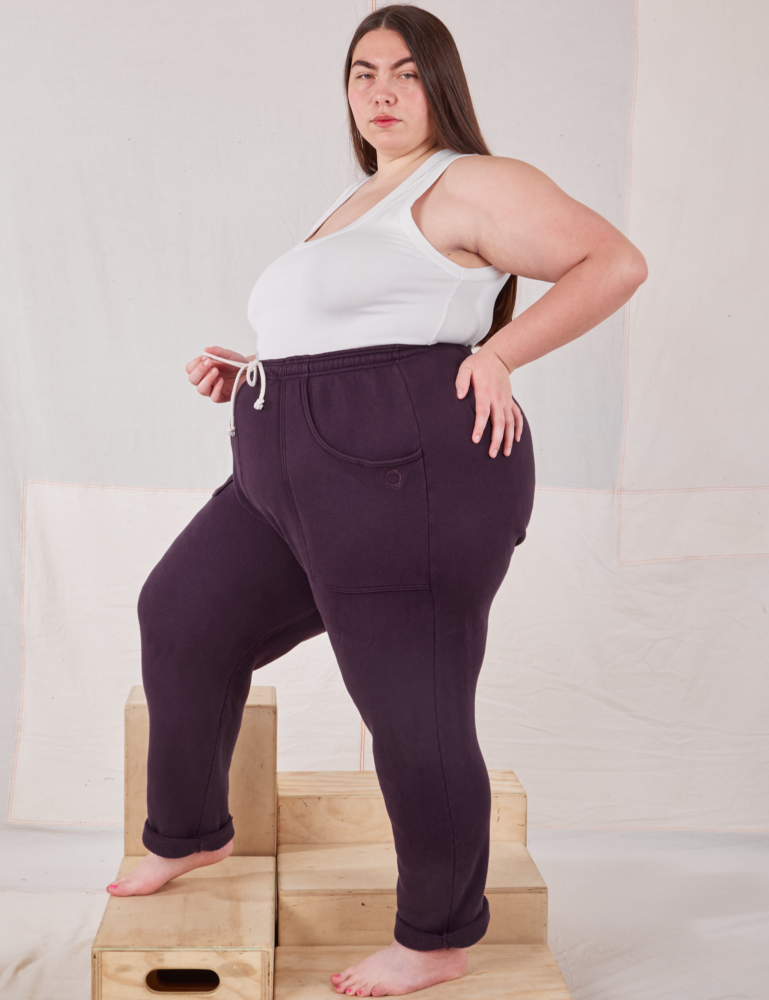 Side view of Rolled Cuff Sweat Pants in Nebula Purple and vintage off-white Cropped Tank on Marielena