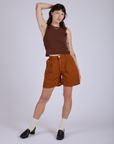 Alex is wearing Pleated Trouser Shorts in Burnt Terracotta and Muscle Tee in Fudgesicle Brown