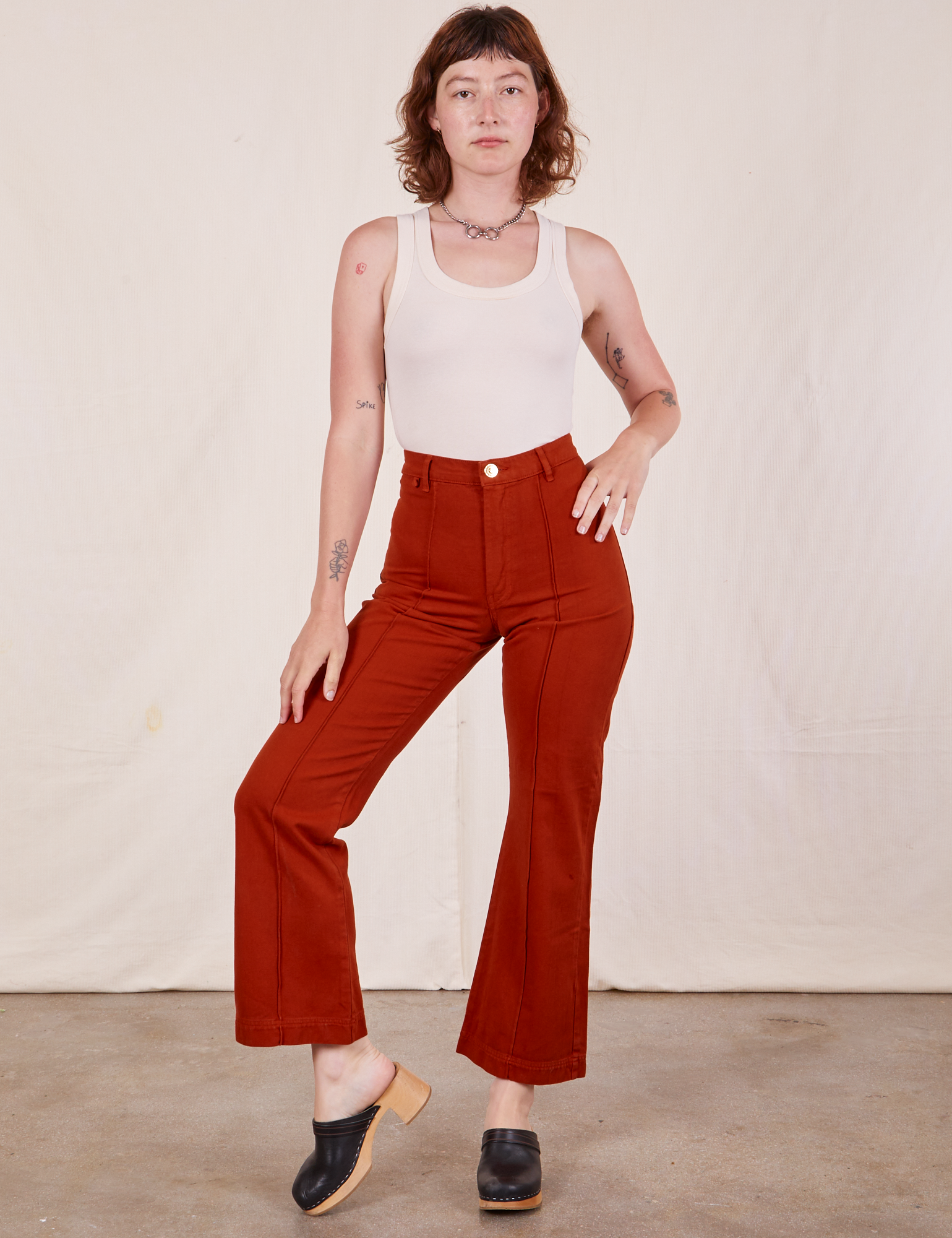 Alex is 5&#39;8&quot; and wearing XS Western Pants in Paprika and vintage off-white Tank Top