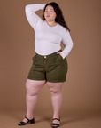 Ashley is 5’7” and wearing 1XL Classic Work Shorts in Surplus Green paired with Long Sleeve Baby Tee in Vintage Tee White