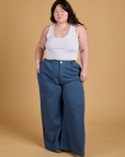 Ashley is 5'7" and wearing 1XL Heritage Wide Leg Trousers in French Blue paired with a vintage tee white Cropped Tank