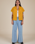 Anthony is wearing Pantry Button-Up in Mustard Yellow and light wash Indigo Wide Leg Trousers