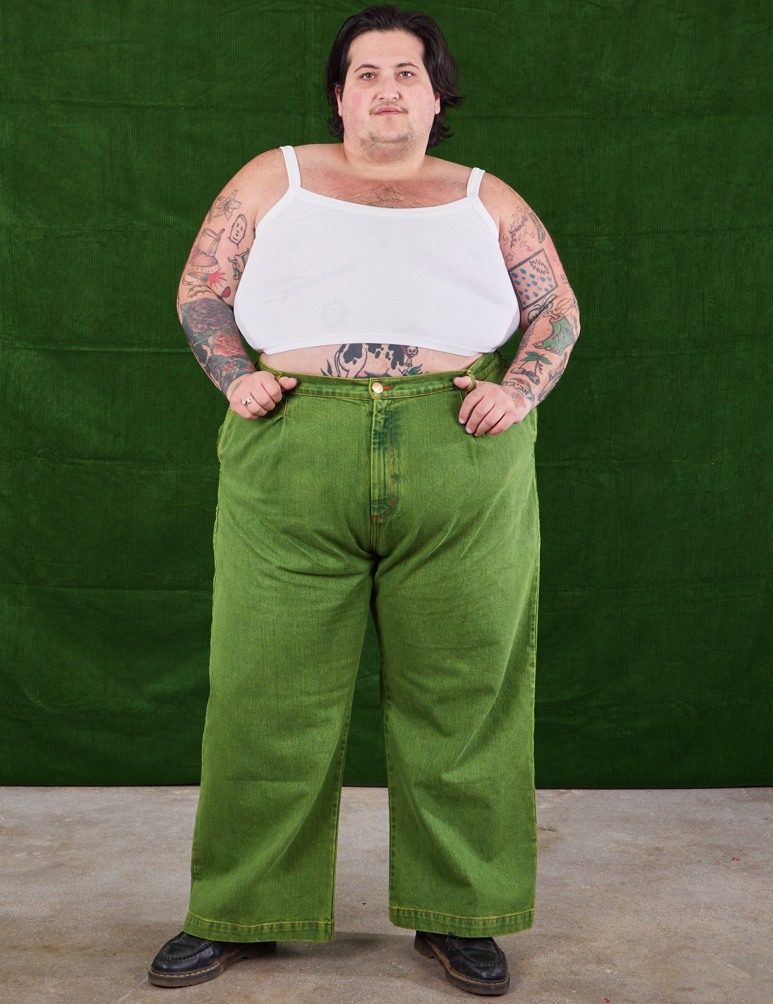 Sam is wearing Overdyed Wide Leg Trousers in Gross Green and Cropped Cami in vintage tee  off-white