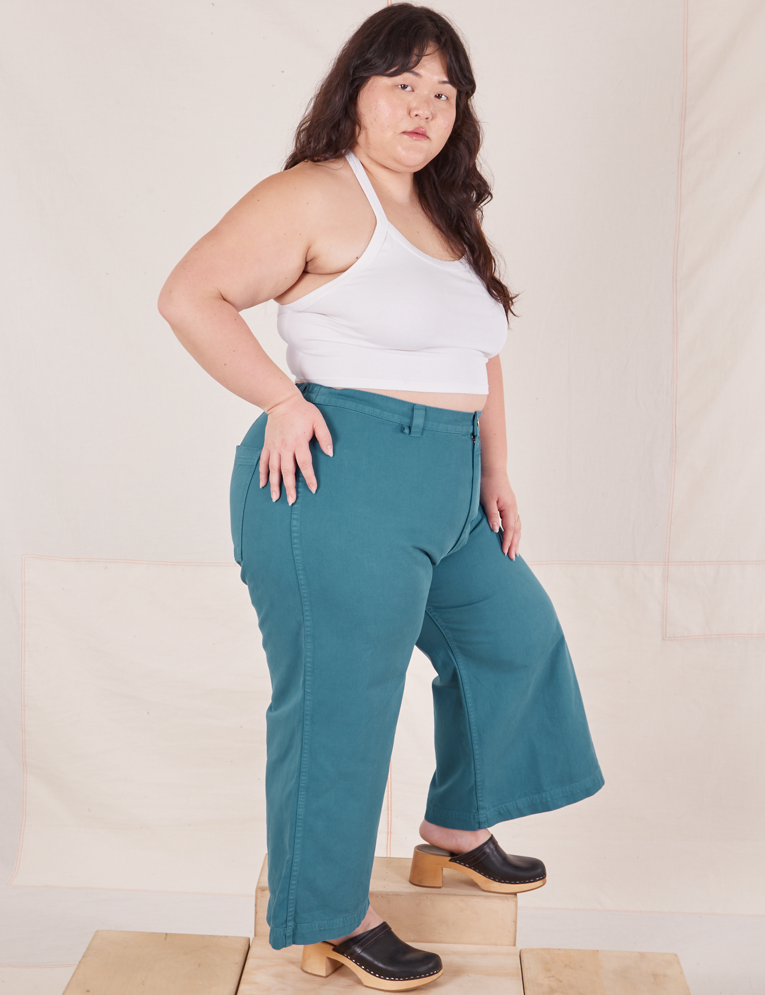 Side view of Petite Bell Bottoms in Marine Blue and Halter Top in vintage tee off-white on Ashley