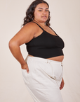 Side view of Cropped Cami in Basic Black and vintage off-white Western Pants worn by Alicia