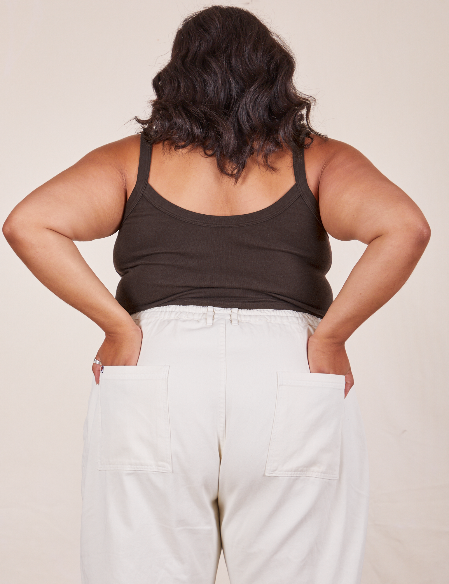 Back view of Cropped Cami in Espresso Brown and vintage tee off-white Western Pants worn by Alicia. She has both hands in the back pant pockets.