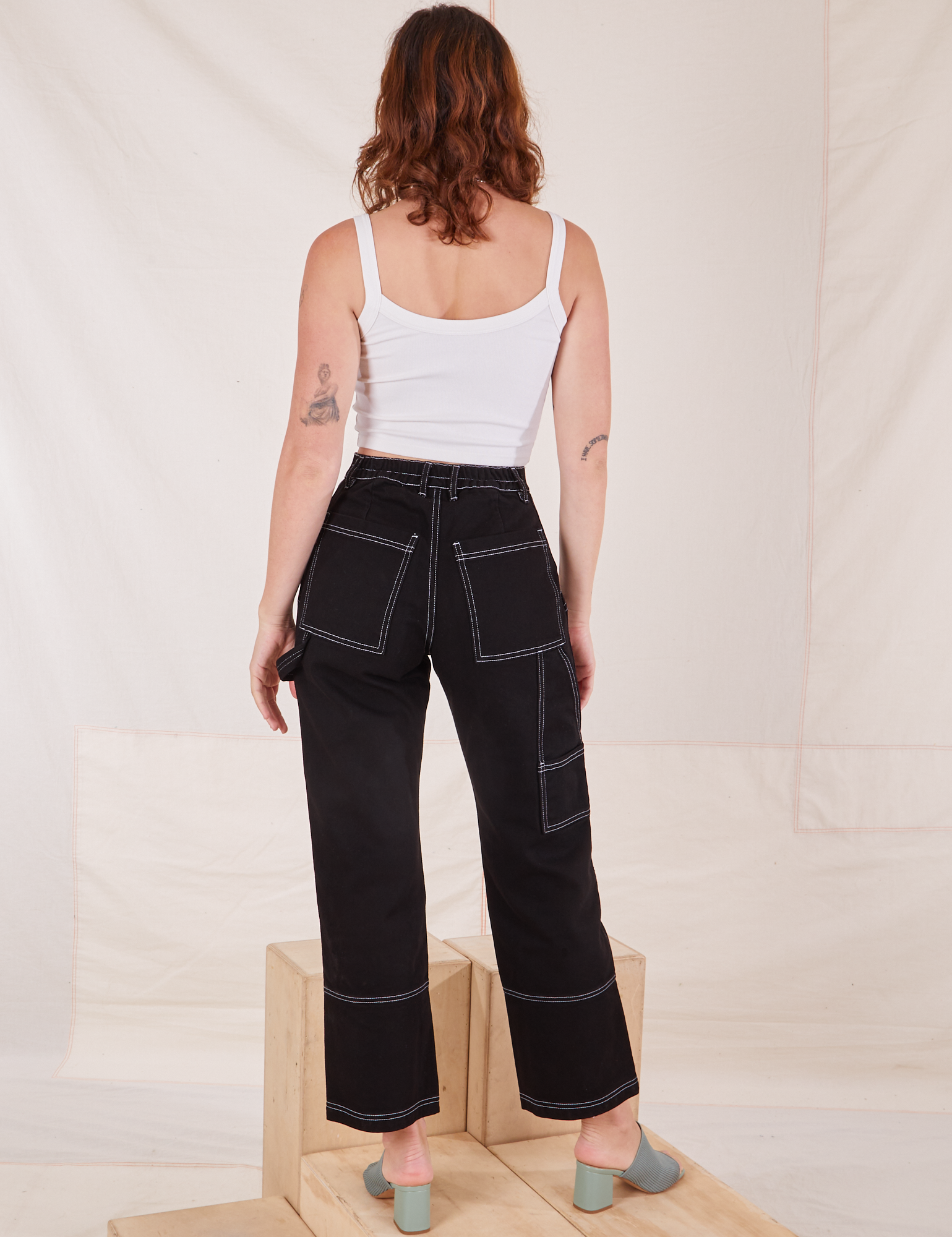 Back view of Carpenter Jeans in Black and Cropped Cami in vintage tee off-white worn by Alex