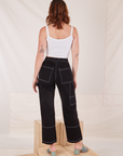 Back view of Carpenter Jeans in Black and Cropped Cami in vintage tee off-white worn by Alex