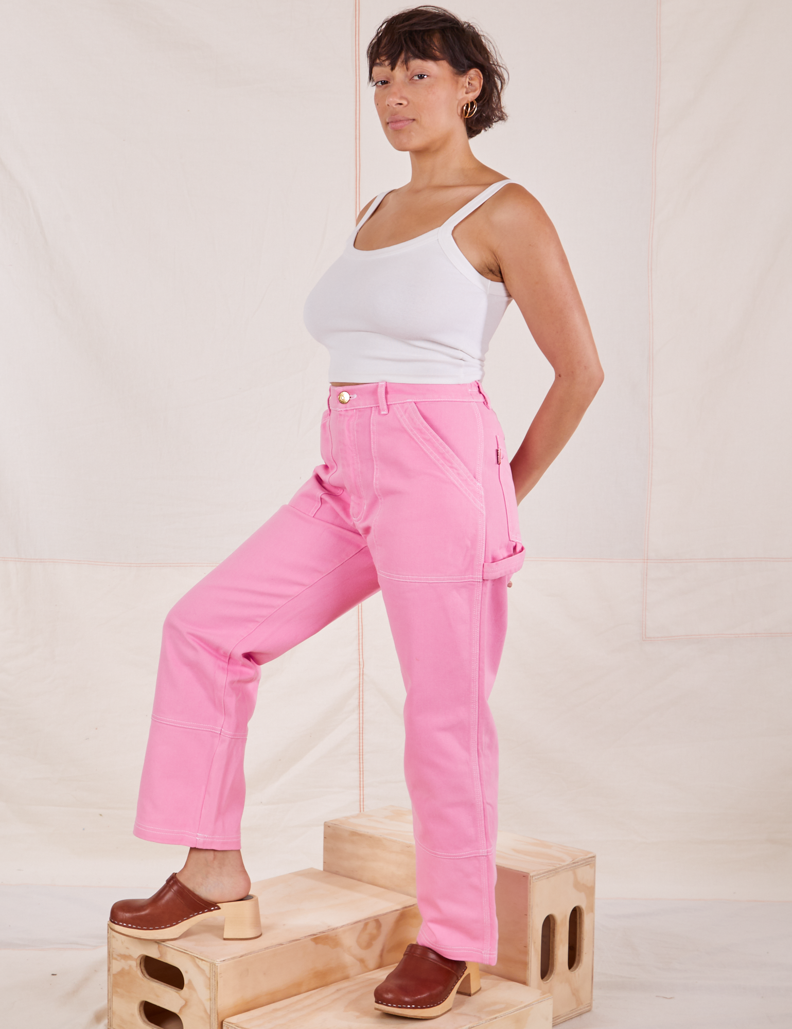 Angled front view of Carpenter Jeans in Bubblegum Pink and Cropped Cami in vintage tee off-white  worn by Tiara