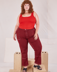Bree is 5'9" and wearing 2XL Railroad Carpenter Jeans in Mustang Red paired with mustang red Square Neck Tank