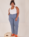Morgan is 5'5" and wearing 1XL Carpenter Jeans in Railroad Stripes paired with Tank Top in vintage tee off-white