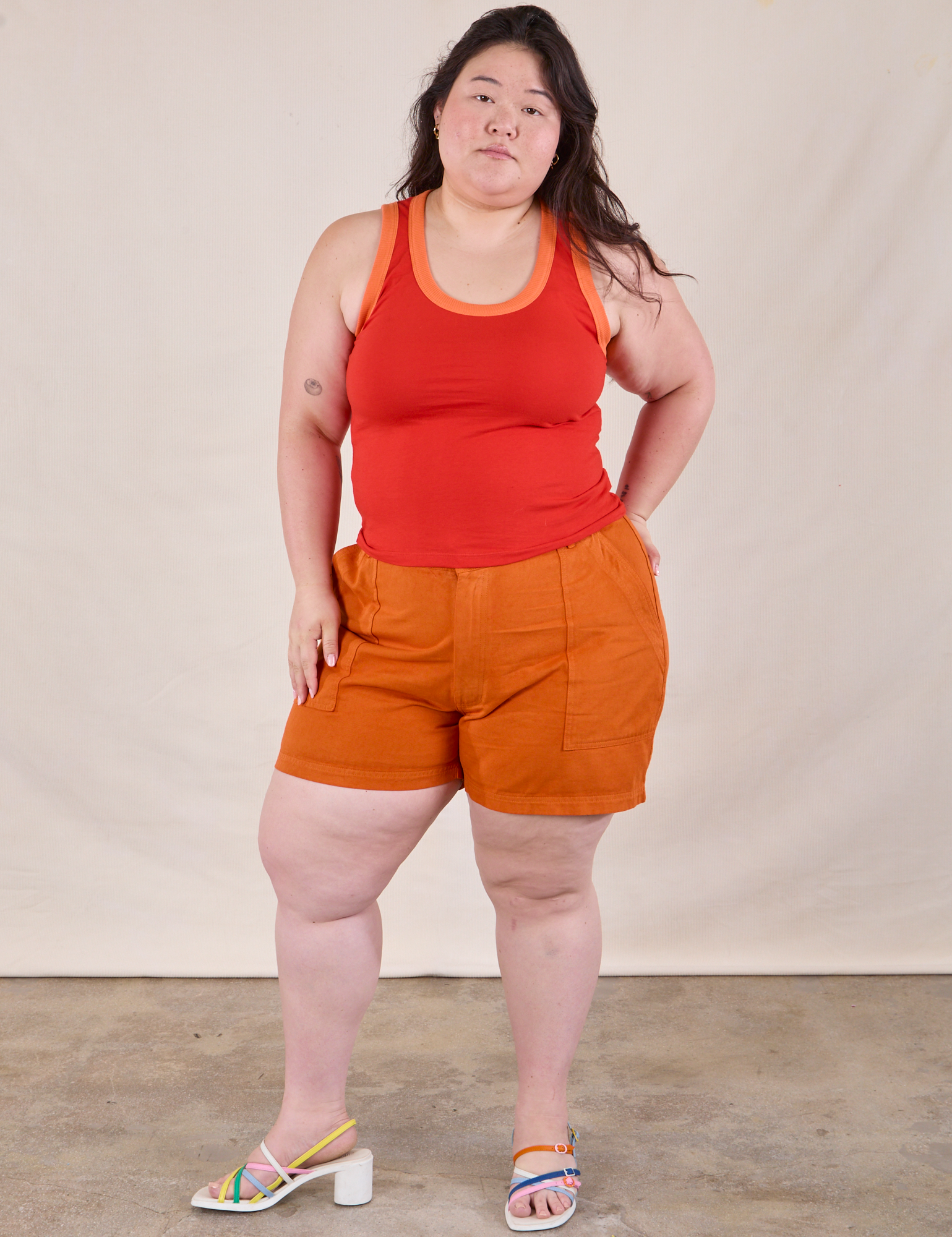 Ashley is wearing Colorblock Cropped Tank in Mustang Red and burnt orange Work Shorts