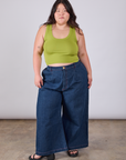 Ashley is wearing Cropped Tank Top in Gross Green paired with dark wash Indigo Wide Leg Trousers