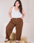 Ashley is 5'7" and wearing 0XL Checker Trousers in Brown & Black and Tank Top in vintage tee off-white