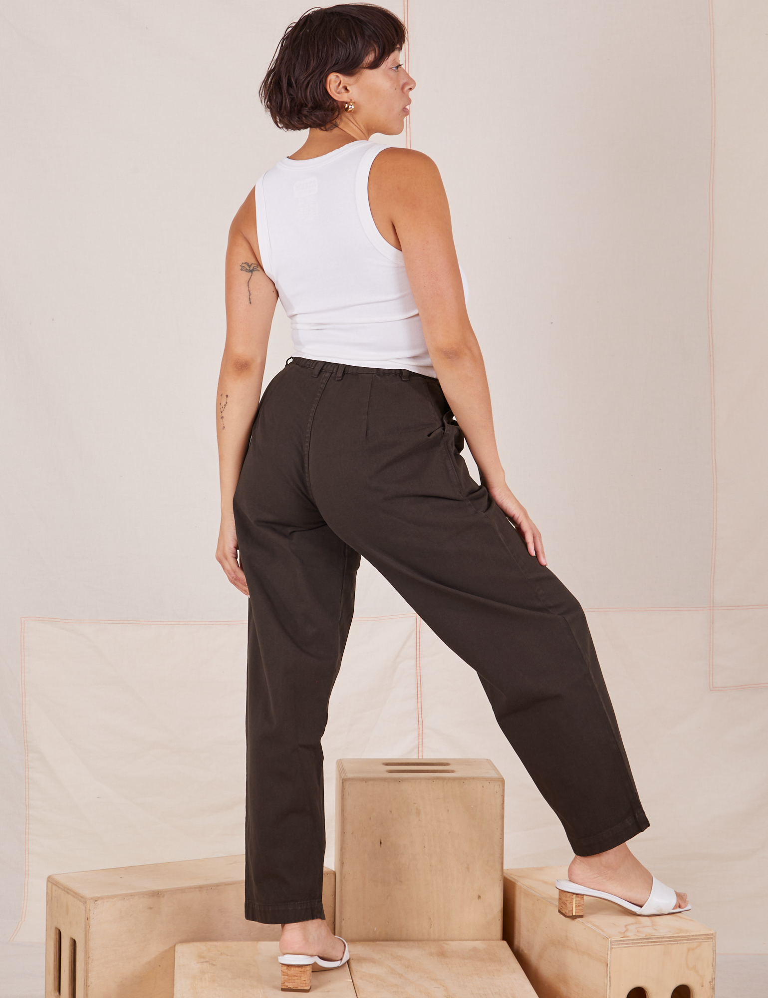 Angled back view of Heavyweight Trousers in Espresso Brown and Cropped Tank Top in vintage tee off-white by Tiara.