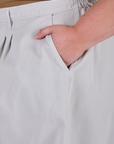 Close up of Juliet's hand in the front pocket of Pleated Trouser Shorts in Dishwater White