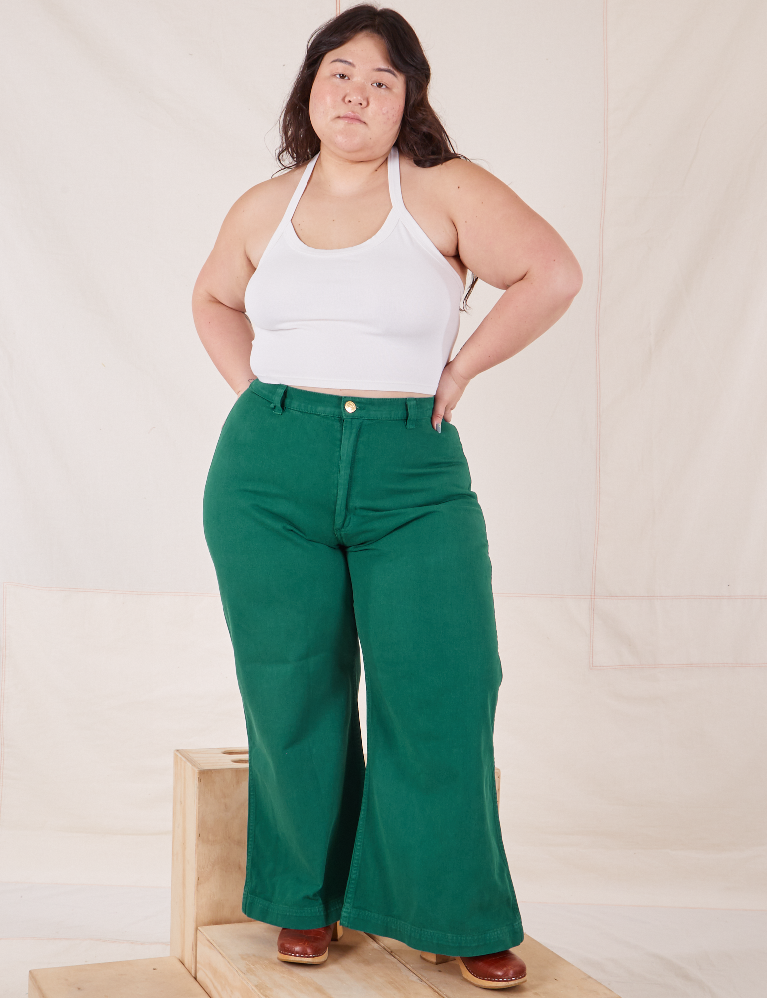 Ashley is wearing Bell Bottoms in Hunter Green and Halter Top in vintage tee off-white