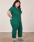 Side view of Petite Short Sleeve Jumpsuit in Hunter Green worn by Ashley