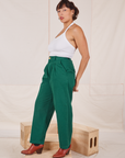 Side view of Heavyweight Trousers in Hunter Green and Halter Top in vintage in off-white worn by Tiara