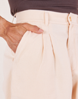 Heritage Trousers in Vintage Off-White front close up. Jesse has their hand in the pocket.