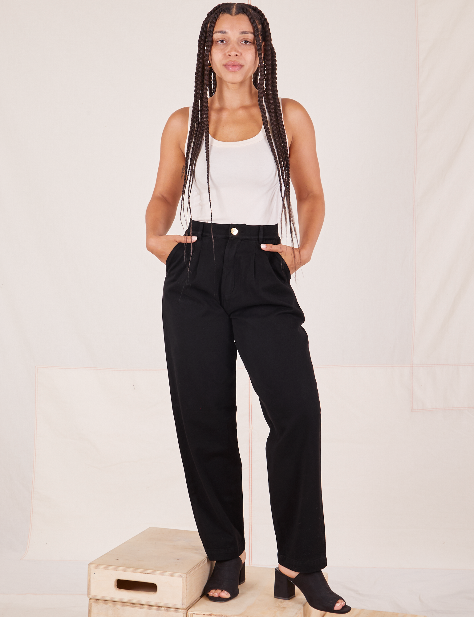 Gabi is 5&#39;7&quot; and wearing XXS Organic Trousers in Basic Black paired with Tank Top in vintage tee off-white