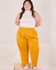 Ashley is 5'7" and wearing 1XL Petite Organic Trousers in Mustard Yellow paired with Sleeveless Turtleneck in vintage tee off-white