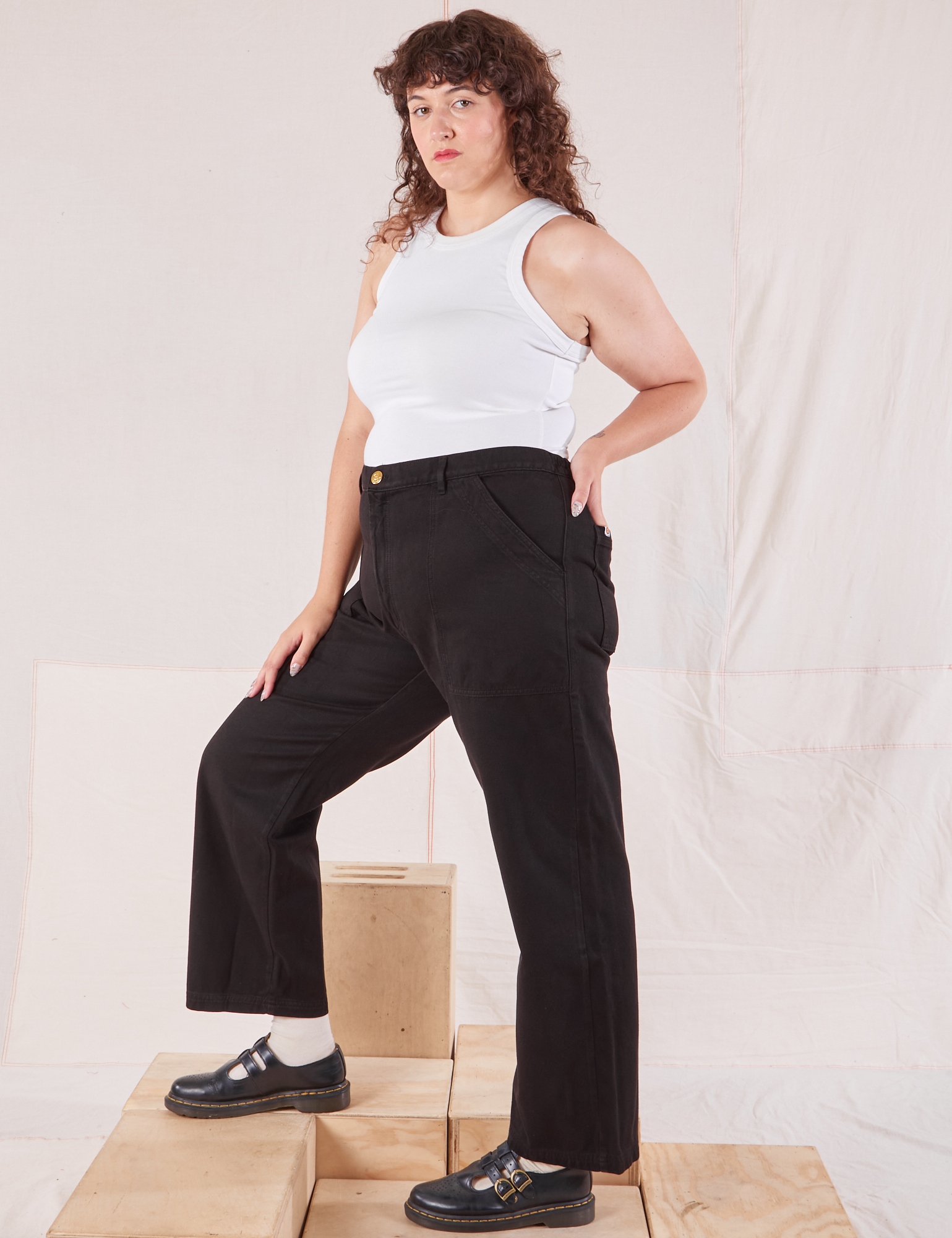 Side view of Organic Work Pants in Basic Black and Racerback Tank in vintage tee off-white on Ryan