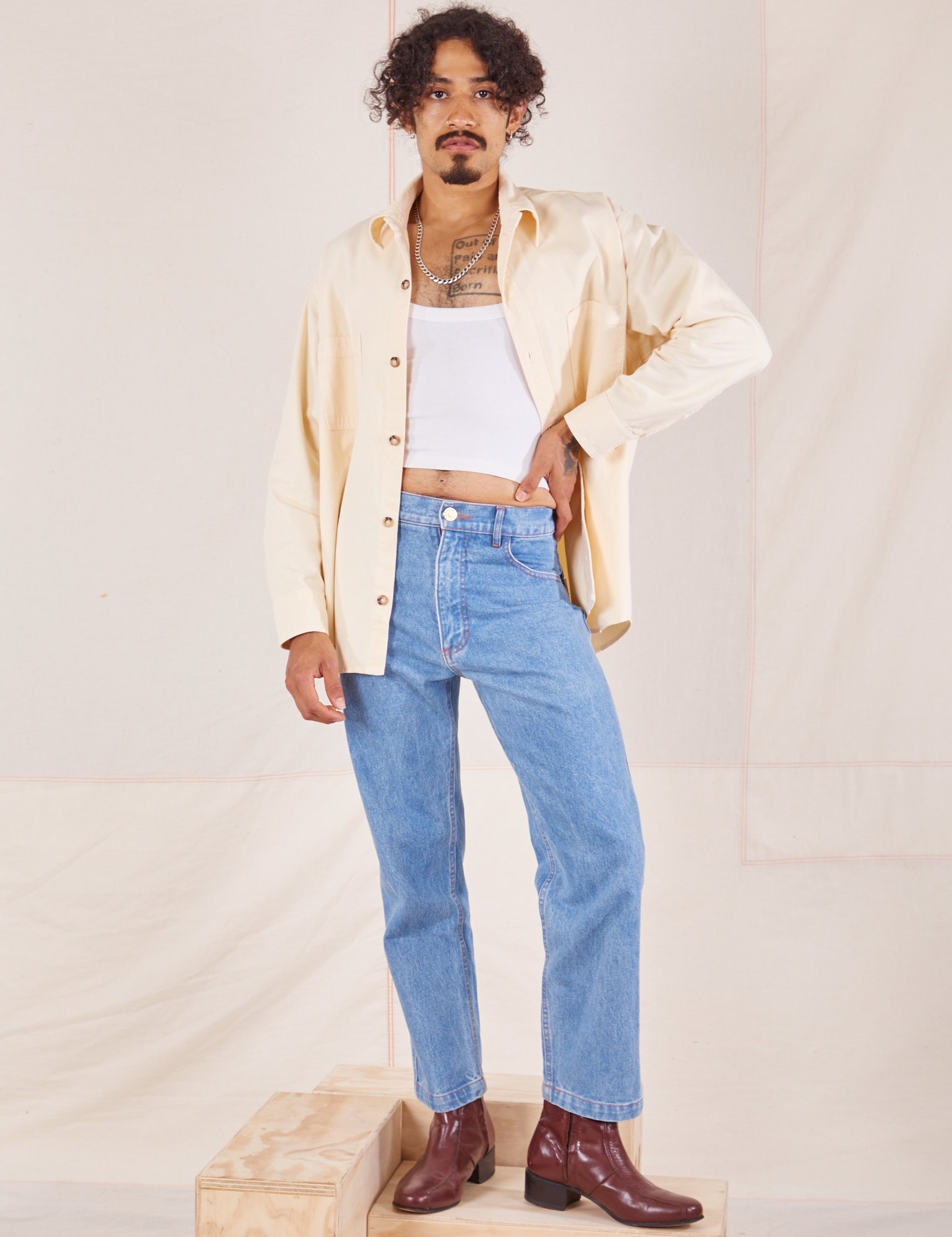 Jesse is wearing Oversize Overshirt in Vintage Tee Off-White and light wash Frontier Jeans