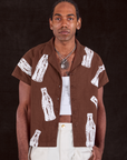 Jerrod is wearing Soda Bottle Pantry Button-Up in Fudgesicle Brown