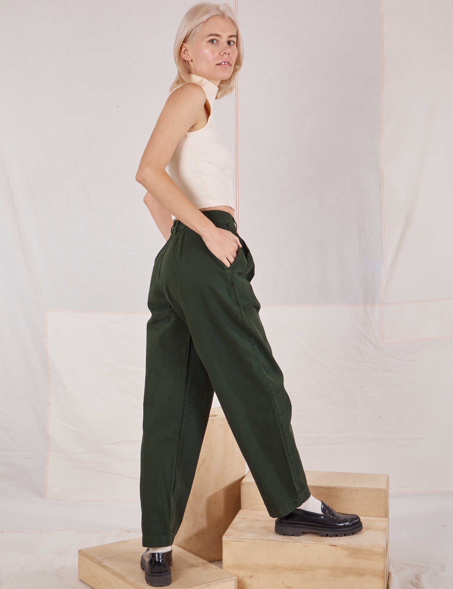 Side view of Heavyweight Trousers in Swamp Green and Sleeveless Turtleneck in vintage tee off-white on Madeline