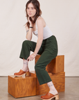 Hana is wearing Petite Work Pants in Swamp Green and Cropped Tank Top in vintage tee off-white