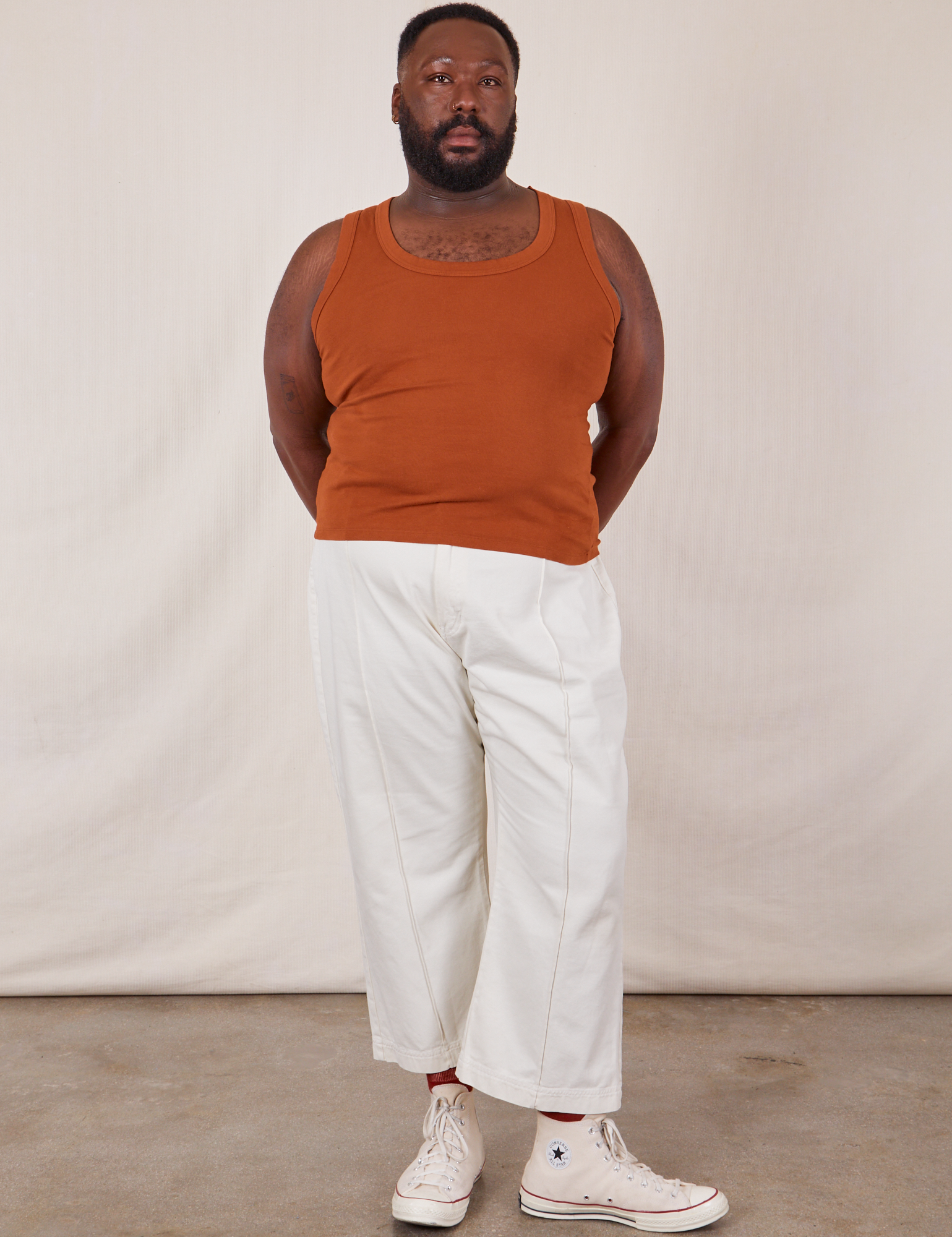 Elijah is 6’0 and wearing 3XL Tank Top in Burnt Terracotta paired with vintage tee off-white Western pants
