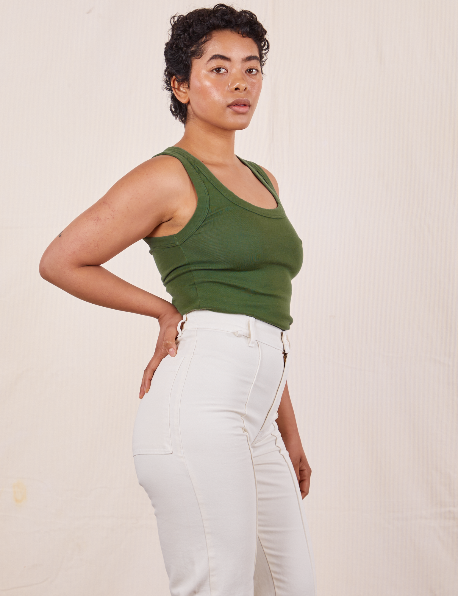 Side view of Tank Top in Dark Emerald Green and vintage tee off-white Western Pants on Mika