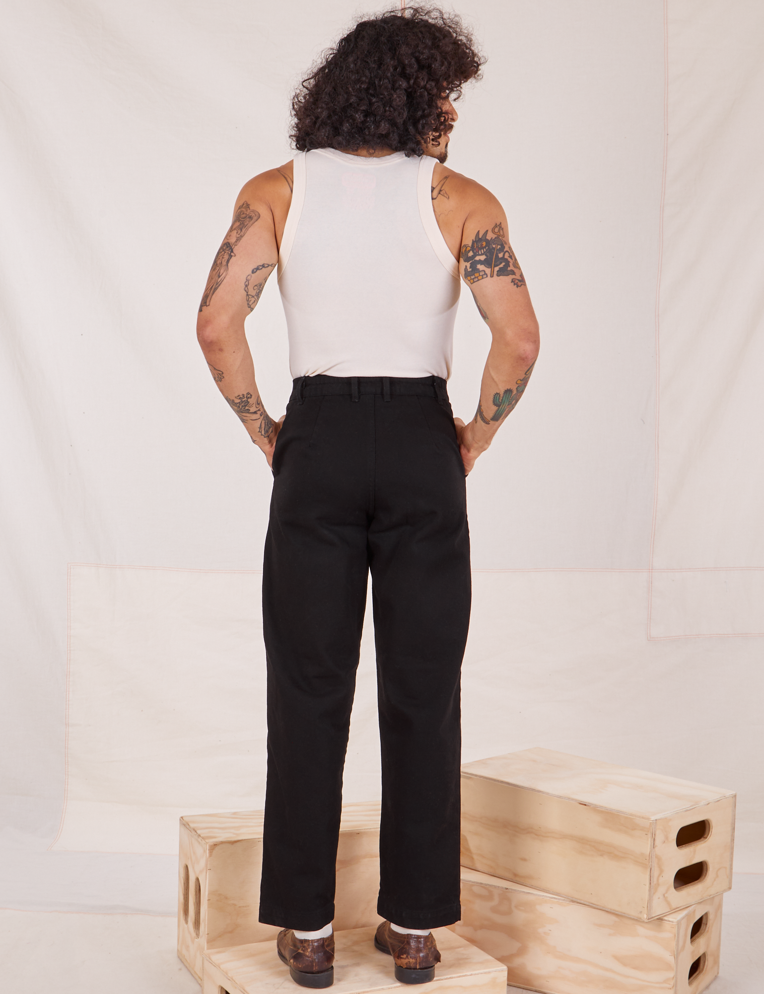 Back view of Denim Trouser Jeans in Black and Tank Top in vintage tee off-white worn by Jesse