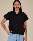 Anthony is wearing a buttoned up Pantry Button-Up in Basic Black
