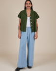 Anthony is wearing Pantry Button-Up in Evergreen and light wash Indigo Wide Leg Trousers