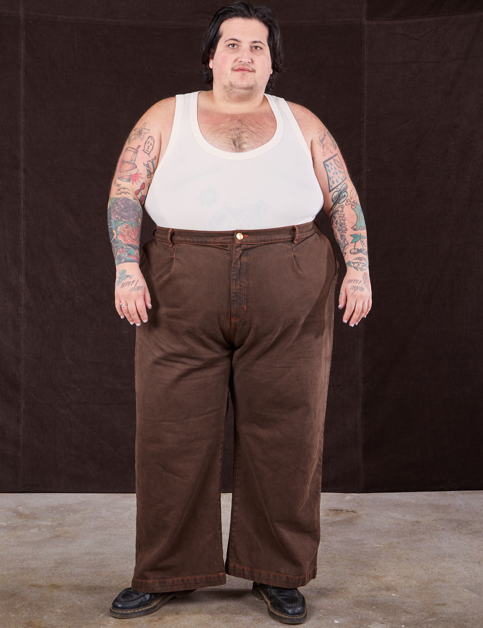 Sam is 5&#39;10&quot; and wearing 2XL Overdyed Wide Leg Trousers in Brown paired with Tank Top in vintage tee off-white