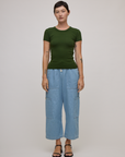 Alex is wearing Baby Tee in Evergreen paired with light wash denim drop pocket pants