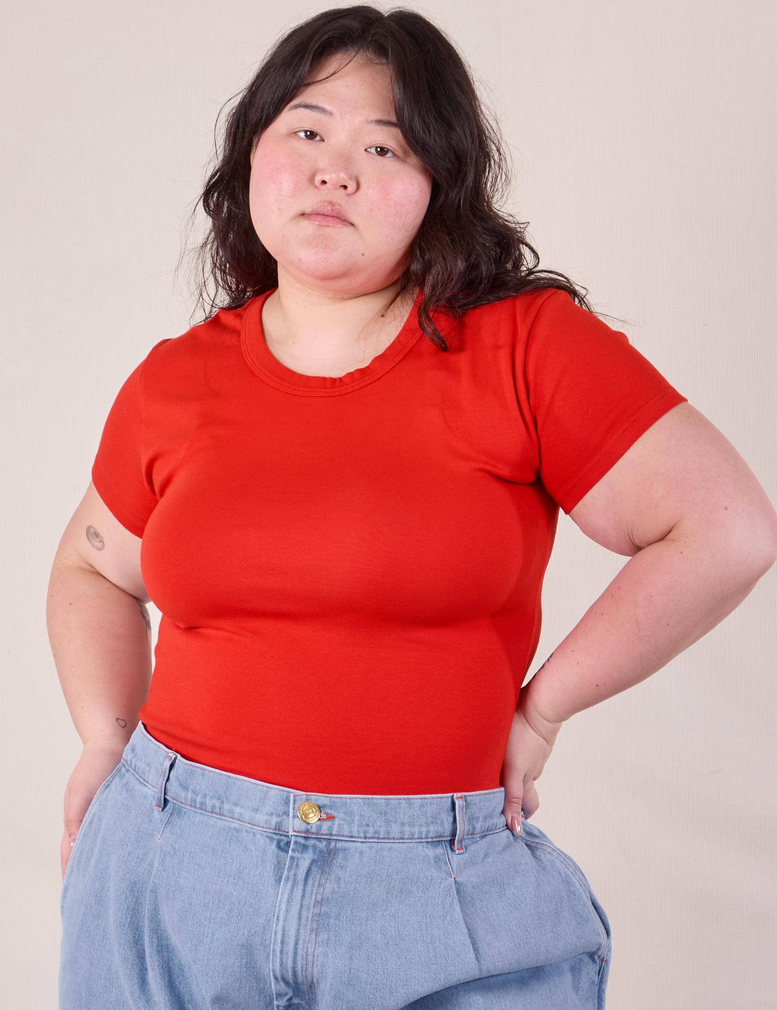 Ashley is 5'7" and wearing L Baby Tee in Mustang Red