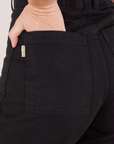 Bell Bottoms in Basic Black back pocket close up. Alex has her hand in the pocket.